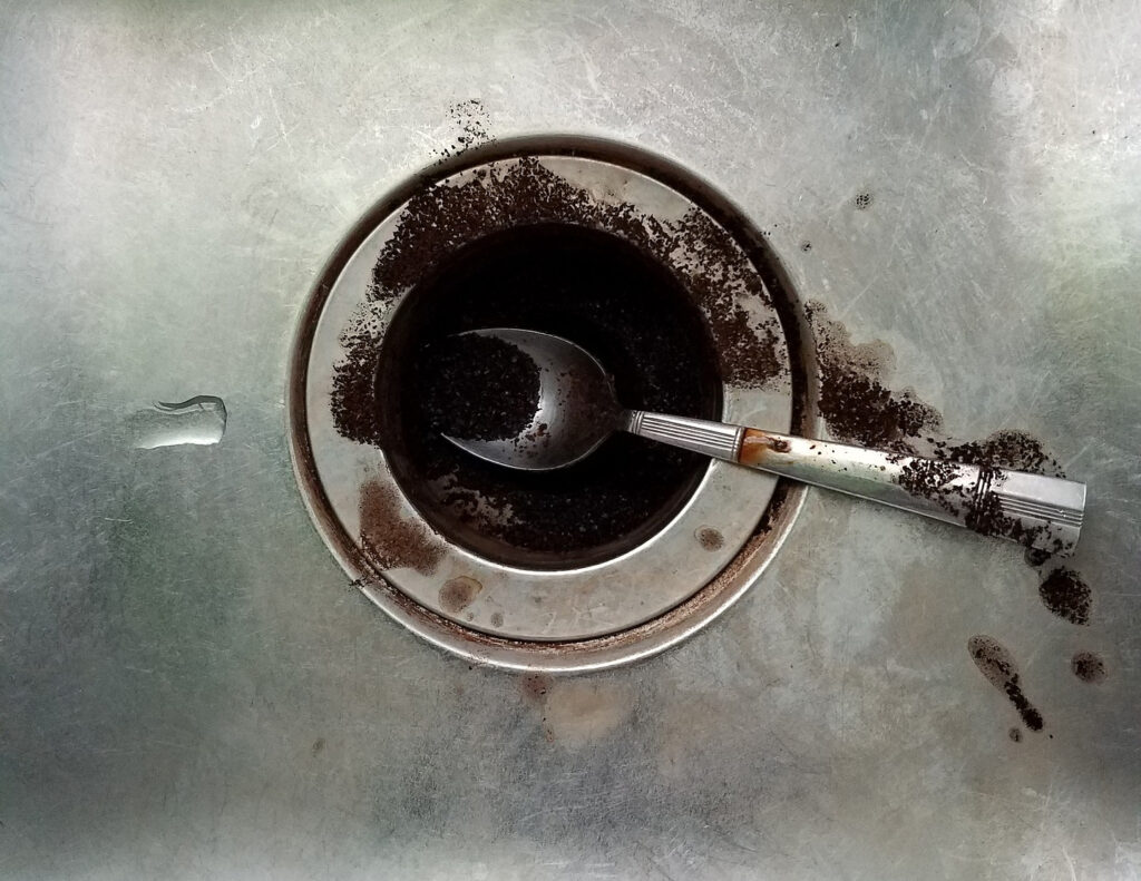 a clogged kitchen drain with coffee grounds
