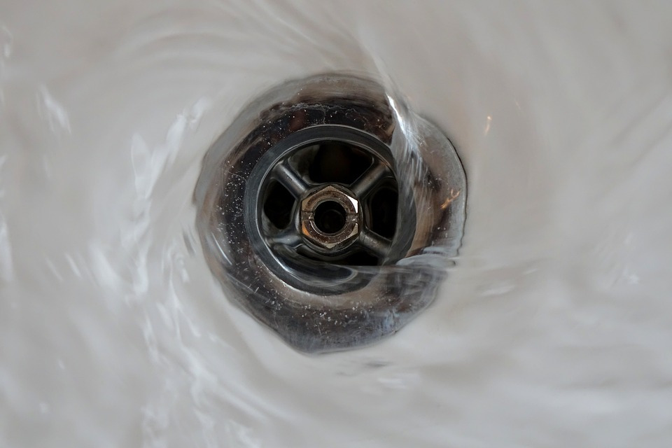 water swirling down sink into drain pipe